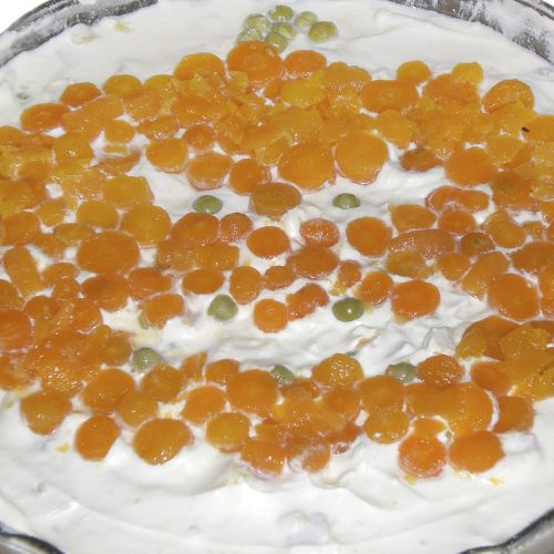 Olivier salad where only the carrots appear on top of the mayonnaise layer